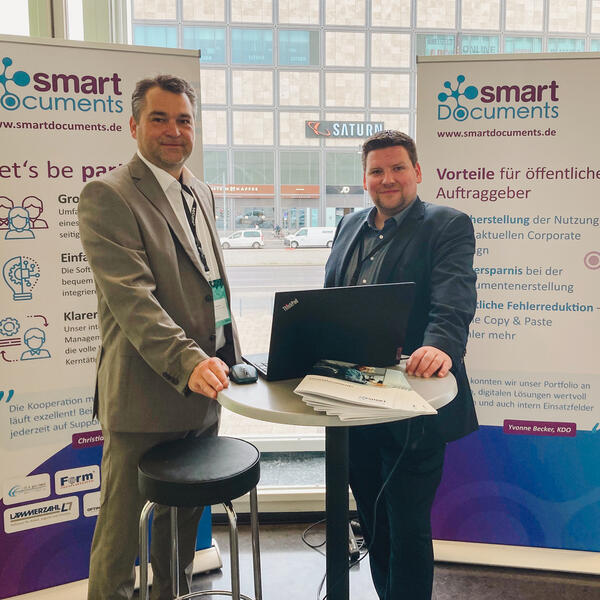 Bild vergrößern: Foto des SmartDocuments Messestandes auf der Veranstaltung Digitaler Staat 2022. Mit auf dem Foto sind Sven Buick und Christoph Winkelmann.