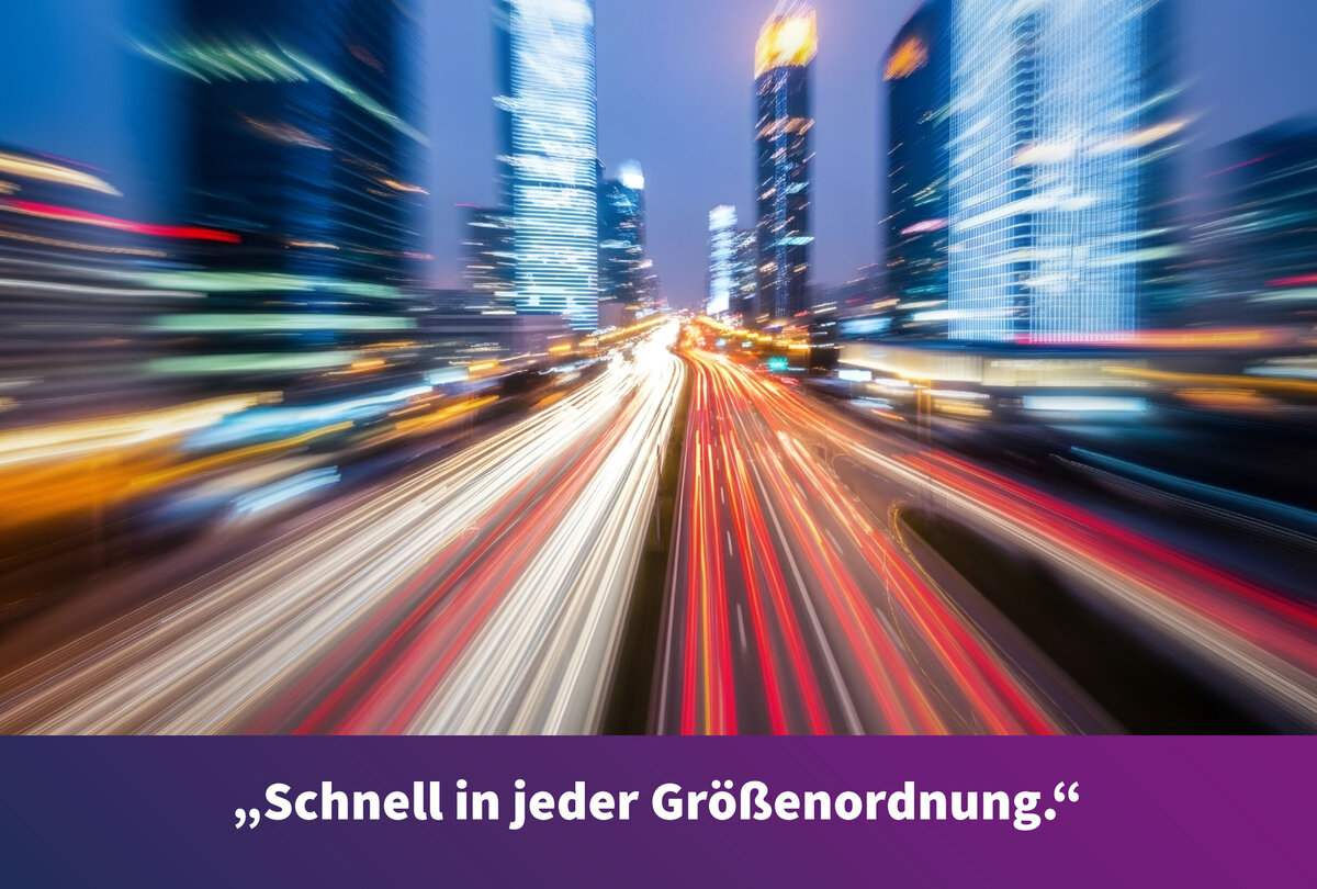 Nachtaufnahme einer modernen Gro&szlig;stadt mit Hochh&auml;usern und mehrspuriger Stra&szlig;e. Die Lichtspuren der Fahrzeuge erzeugen den Eindruck hoher Geschwindigkeit. Am unteren Bildrand steht der Text: &raquo;Schnell in jeder Gr&ouml;&szlig;enordnung.&laquo;