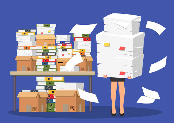 Vektorgrafik: Schreibtisch mit Ordnern, Kisten und massig Papier. Unter dem Schreibtisch sind noch weitere Papierstapel. Neben dem Schreibtisch ist eine Frau abgebildet, die einen großen Papierstapel in den Händen hält, sodass von der Frau nur die Beine erkennbar sind.