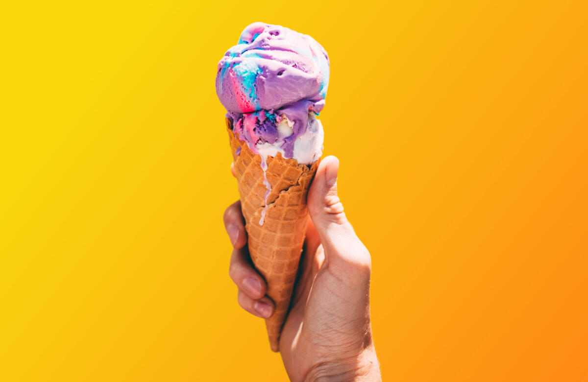 Foto: Hand mit Eiswaffeln und buntem Eis.
