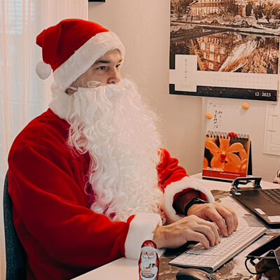 Bild vergrößern: Fotoaufnahme Schreibtisch mit Notebook im Hintergrund und Schokoladennikolaus.
